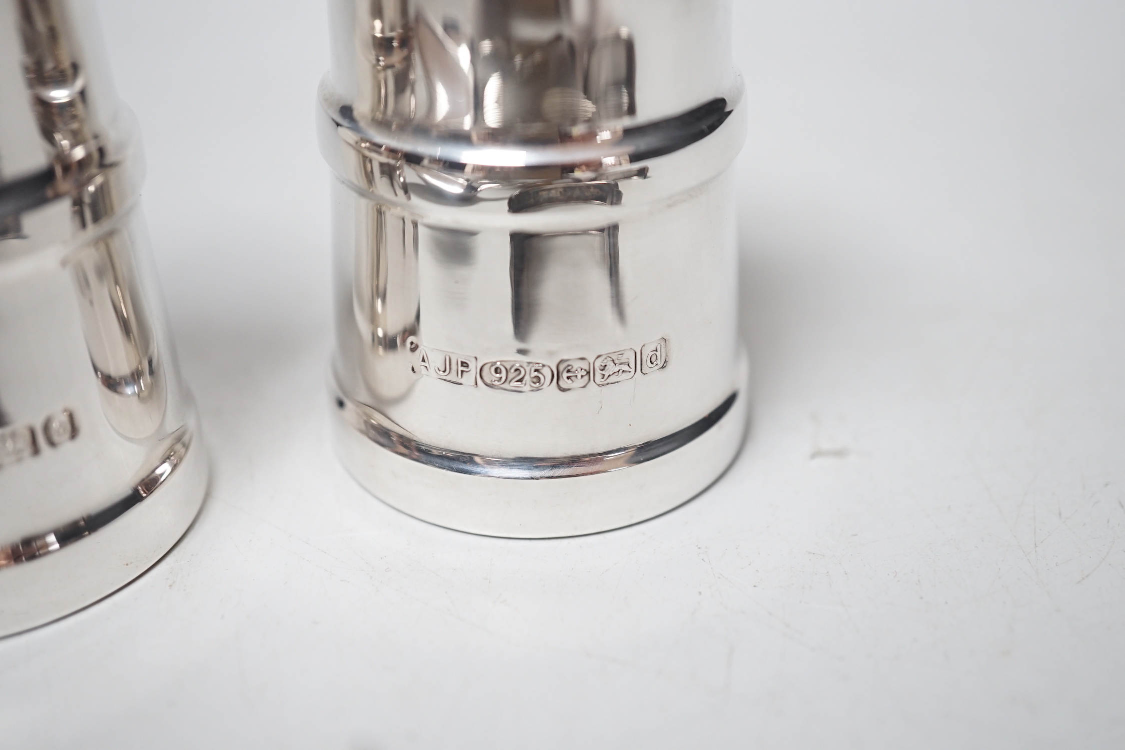 A modern pair silver mounted salt and pepper grinders, 10.6cm, a Georgian silver table spoon, A Victorian mother of pearl handled spoon and a damaged silver bangle.